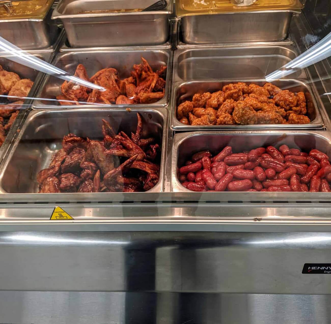 Photo of self serve chicken wings and other hot food items.